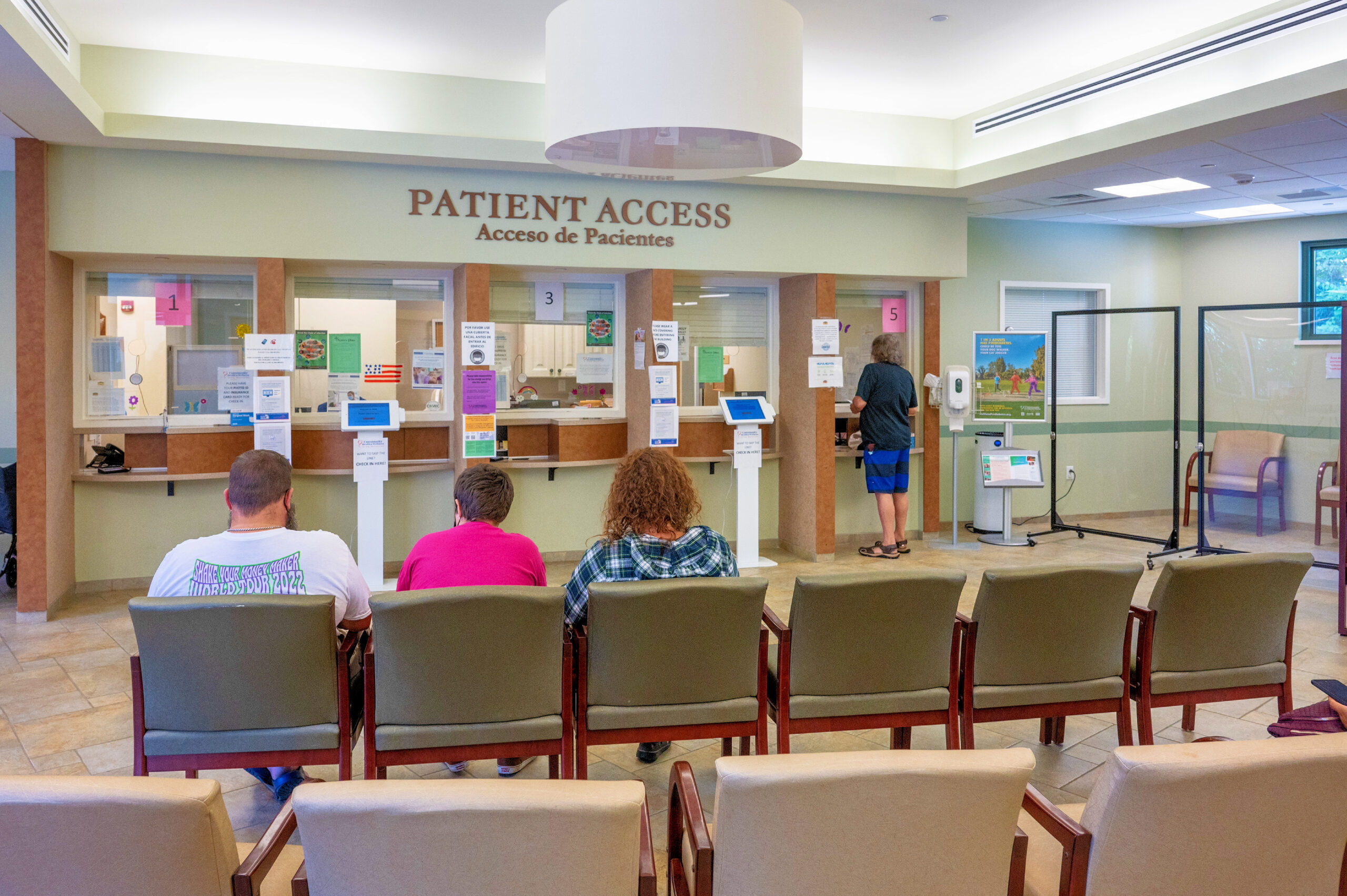 Patients wait inside a waiting room.